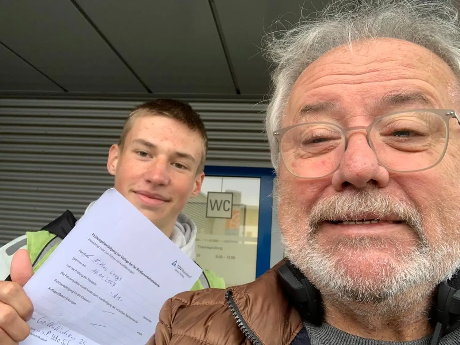 Fahrschulteam Tarnovski GbR, ein alter Mann und ein Junge zeigen das Zertifikat