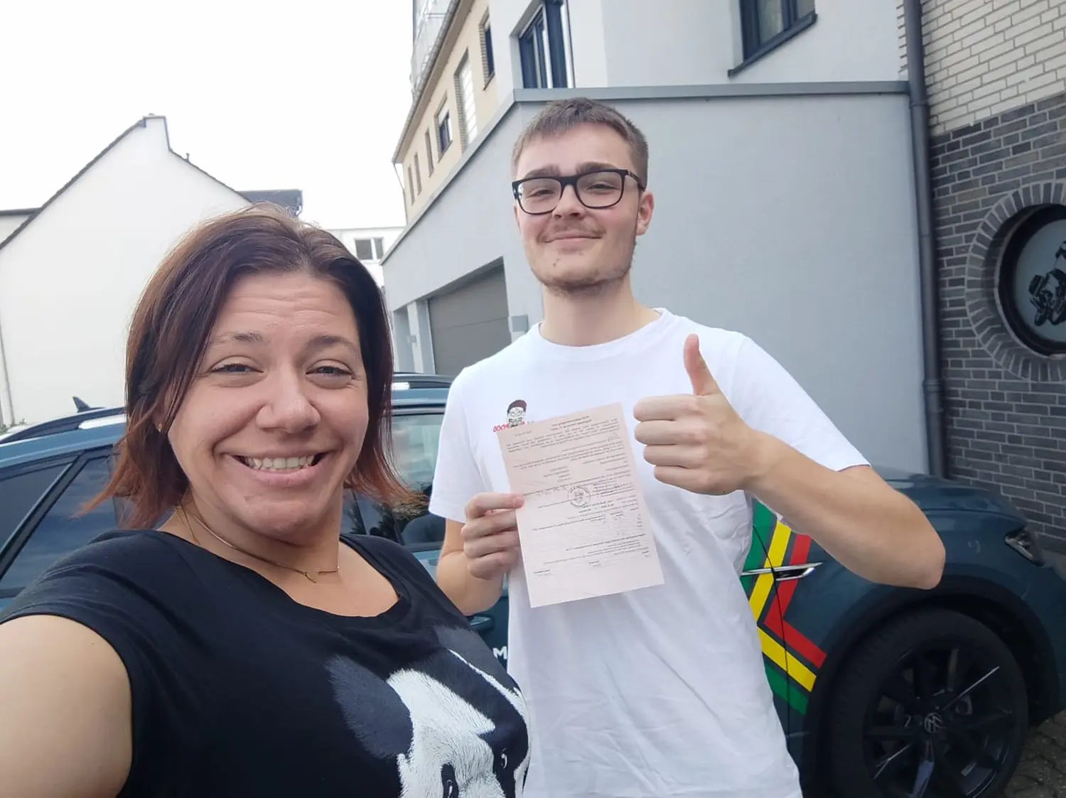 Fahrschulteam Tarnovski GbR, eine lächelnde Frau und ein Junge, der das Zertifikat zeigt