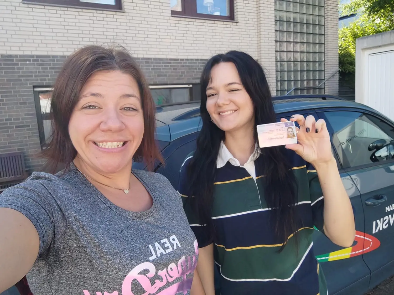Fahrschulteam Tarnovski GbR, eine lächelnde Frau und ein Mädchen, das die Lizenzkarte zeigt